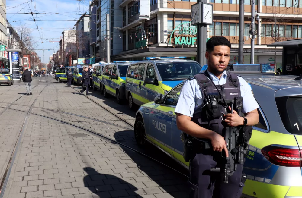 03 March 2025, Baden-W&uuml;rttemberg, Mannheim: A police officer secures a street in the city center during a large-scale police operation. Following an incident involving a car in Mannheim city center that left at least one person dead and several injured, the suspected driver has been arrested, according to police. According to the police, a vehicle had driven into a crowd of people. Photo: Ren&eacute; Priebe/dpa