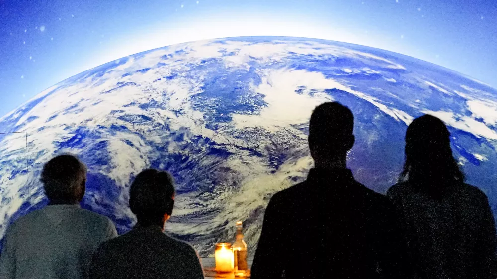 People watch the preview of the new digital exhibition "Destination Cosmos" at the former gas plant Phoenix in Dortmund, Germany, Thursday, Sept. 28, 2023. The multimedia presentation of Phoenix des Lumieres art center shows the history of man's desire to explore space from the earliest stargazers to the International Space Station and the exploration of Mars. (AP Photo/Martin Meissner)
