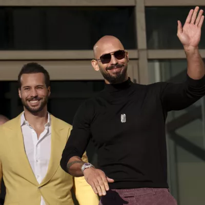 FILE - Andrew Tate waves as he exits the Bucharest Tribunal with his brother Tristan, in Bucharest, Romania, Thursday, Jan. 9, 2025. (AP Photo/Vadim Ghirda, File)