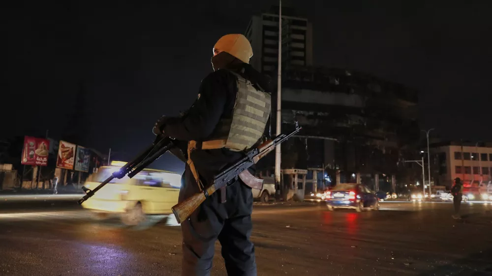 A member of the government security forces stands guard at a street in Damascus, Syria, Thursday, March 6, 2025. (AP Photo/Omar Sanadiki)