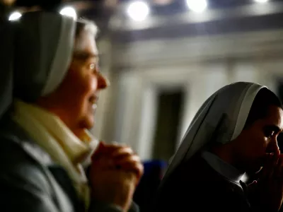 FILE PHOTO: Faithful listen to an audio message by Pope Francis at the Vatican, March 6, 2025. REUTERS/Yara Nardi/File Photo