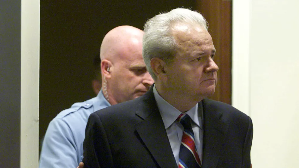 *** FILE *** Former Yugoslav President Slobodan Milosevic, right, with court security guard behind him, enters the U.N. war crimes tribunal in The Hague, Tuesday July 3, 2001. Milosevic has died in the UN war crimes tribunal's detention center in the Hague Saturday March 11, 2006 according to Belgrade's B-92 and Serbia's state radio. He was 65.(AP Photo/pool)