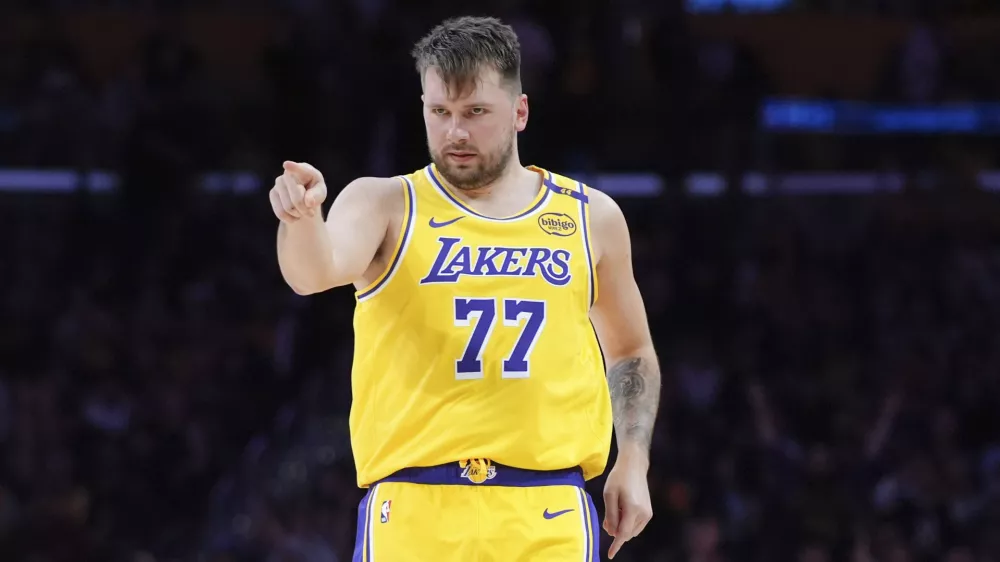 Los Angeles Lakers' Luka Doncic (77) points to his teammate after making a basket during the second half of an NBA basketball game against the New Orleans Pelicans Tuesday, March 4, 2025, in Los Angeles. (AP Photo/Jae C. Hong)