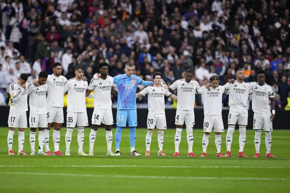 Players of Real Madrid observe a minute of silence prior to the Spanish La Liga soccer match between Real Madrid and Rayo Vallecano at the Santiago Bernabeu stadium in Madrid, Spain, Sunday, March 9, 2025. (AP Photo/Manu Fernandez)