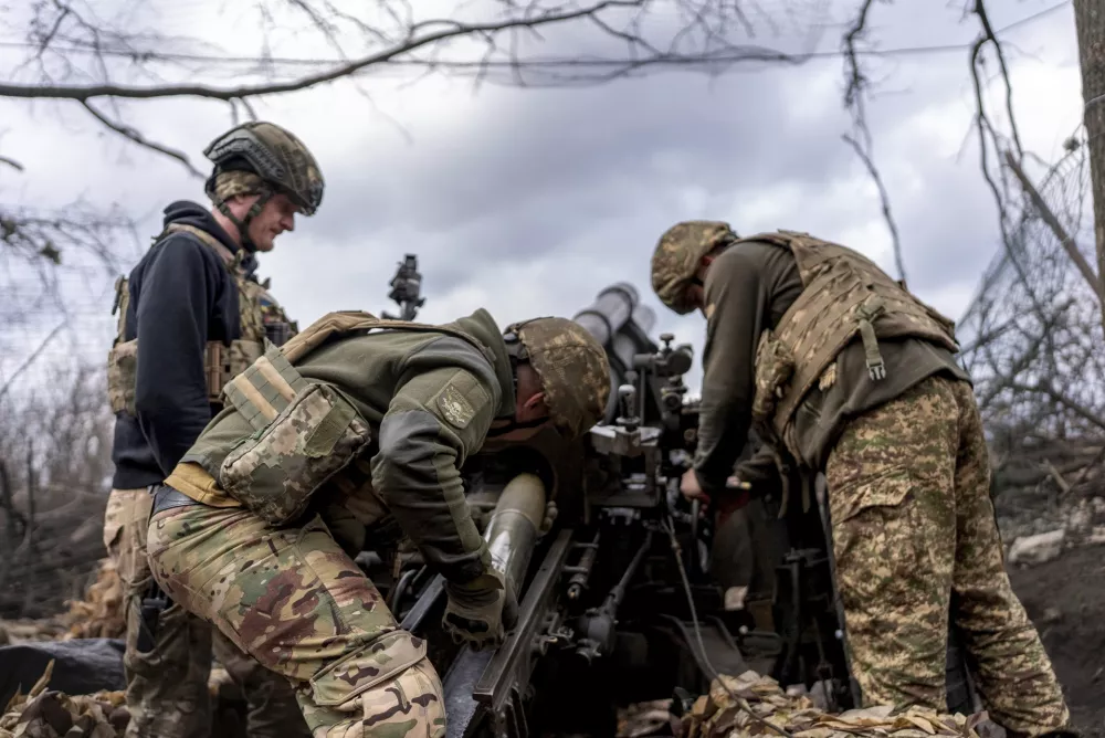 Ukrainian servicemen of Khartia brigade loading shell into M101 Howitzer before firing towards Russian positions in Kharkiv region, Ukraine, Wednesday, March 12, 2025. (AP Photo/Alex Babenko)