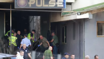 Police officers hold plastic bags on the site of a nightclub in the town of Kocani, North Macedonia, Sunday, March 16, 2025, following a massive fire in the nightclub early Sunday. (AP Photo/Visar Kryeziu)