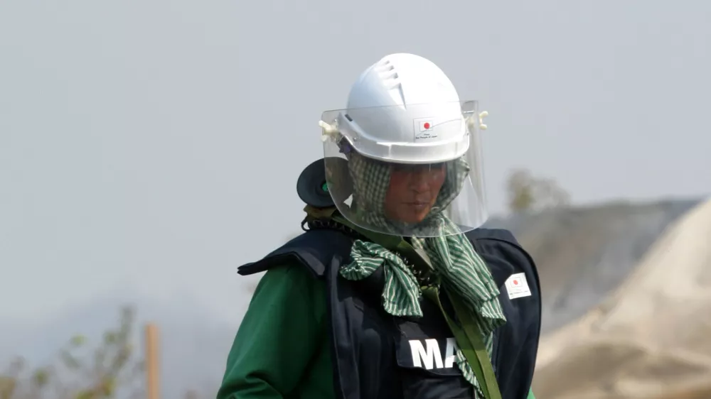 Cambodian woman On Sovannareth, 30, searches for mines in a minefield near the village of Ta Krouk, some 350km northwest of the capital Phnom Penh. As a member of what is one of the world's first all-women demining teams, she is working to clear mines and unexploded bombs left from decades of conflict in the impoverished southeast Asian nation. Picture taken February 11, 2004. TO MATCH FEATURE CAMBODIA-MINES REUTERS/Chor Sokunthea
