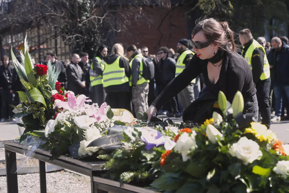 A woman lays flowers for the victims of a massive nightclub fire in the town of Kocani, in Skopje, North Macedonia, Tuesday, March 18, 2025. (AP Photo/Boris Grdanoski)