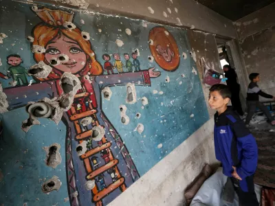 A boy looks at a damaged wall as Palestinians inspect the site of an Israeli airstrike on an UNRWA-run clinic where displaced people shelter, in Jabalia in the northern Gaza Strip April 2, 2025. REUTERS/Mahmoud Issa   TPX IMAGES OF THE DAY
