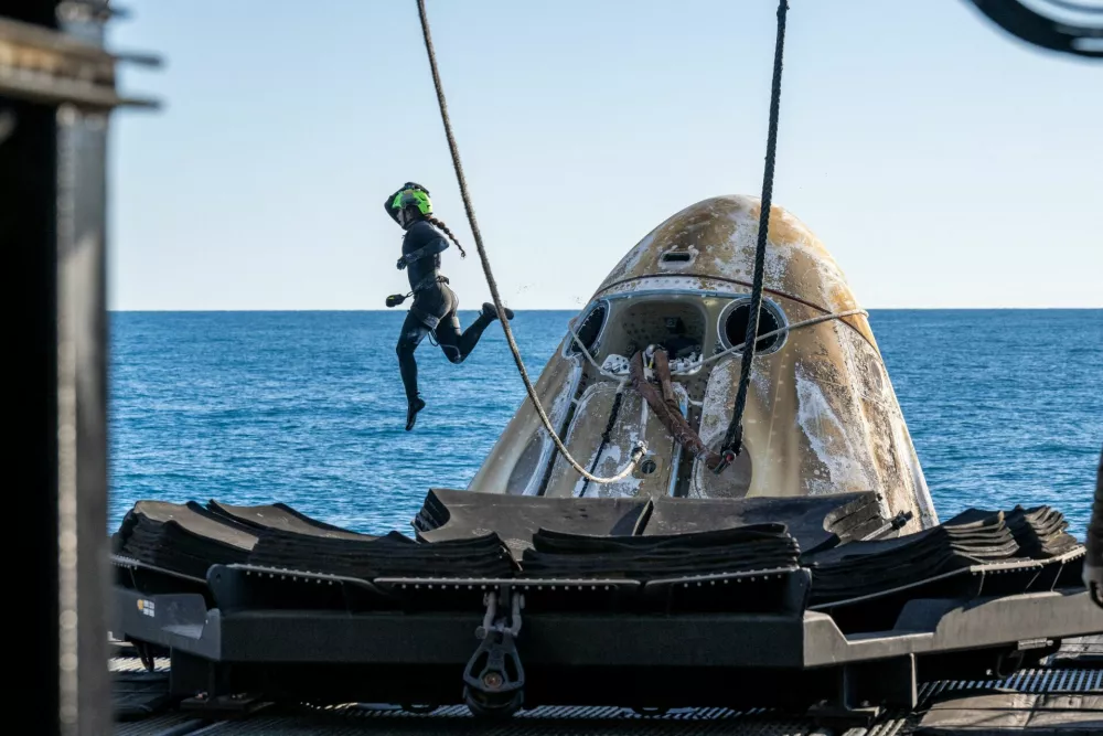 Support teams work around a SpaceX Dragon spacecraft shortly after it landed with NASA astronauts Nick Hague, Suni Williams, Butch Wilmore, and Roscosmos cosmonaut Aleksandr Gorbunov aboard in the water off the coast of Tallahassee, Florida, Tuesday, March 18, 2025. NASA/Keegan Barber/ Handout via REUTERS