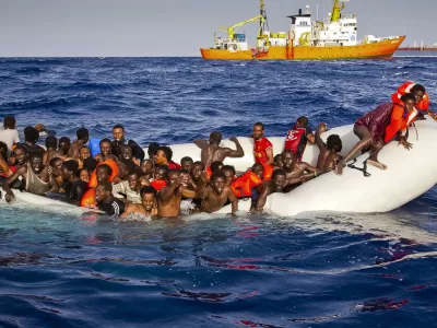 In this photo taken on Sunday, April 17, 2016 migrants ask for help from a dinghy boat as they are approached by the SOS Mediterranee's ship Aquarius, background, off the coast of the Italian island of Lampedusa. The European Union's border agency says the number of migrants crossing the Mediterranean Sea to Italy more than doubled last month. Frontex said in a statement on Monday that almost 9,600 migrants attempted the crossing, one of the most perilous sea voyages for people seeking sanctuary or jobs in Europe. (Patrick Bar/SOS Mediterranee via AP)