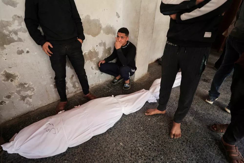 A mourner reacts next to the body of a Palestinian killed in Israeli strikes, at Al-Ahli Arab Baptist hosptial, in Gaza City, March 19, 2025. REUTERS/Dawoud Abu Alkas