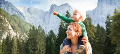 Srečna mamica z otročičkom med lepimi gorami. / Foto: Istock