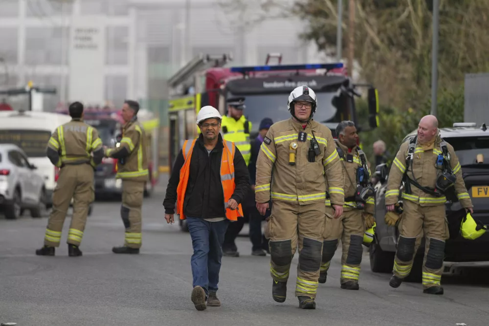 Firefighters wait at the area around the North Hyde electrical substation, which caught fire Thursday night and lead to a closure of Heathrow Airport in London, Friday, March 21, 2025.(AP Photo/Kirsty Wigglesworth)