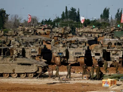 FILE PHOTO: Israeli soldiers work by military vehicles, amid a ceasefire between Israel and Hamas, near the border with Gaza, in Israel, February 15, 2025. REUTERS/Amir Cohen/File Photo