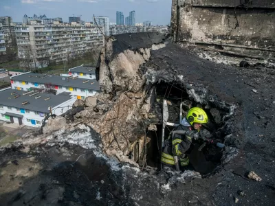 FILE PHOTO: A firefighter works at a site an apartment building hit by a Russian drone strike, amid Russia's attack on Ukraine, in Kyiv, Ukraine March 23, 2025. REUTERS/Vladyslav Musiienko/File Photo