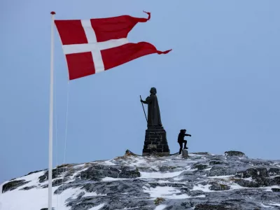 FILE PHOTO: A man walks as Danish flag flutters next to Hans Egede Statue ahead of a March 11 general election in Nuuk, Greenland, March 9, 2025. REUTERS/Marko Djurica/File Photo