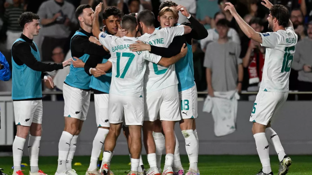 24 March 2025, New Zealand, Auckland: New Zealand's Elijah Just celebrates scoring his side's third goal with teammates during the FIFA World Cup 2026 Oceania Qualifier match against New Caledonia at Eden Park in Auckland. Photo: Andrew Cornaga/AAP/dpa