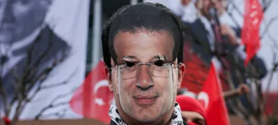 A person wears a cutout mask of Istanbul Mayor Ekrem Imamoglu who was jailed as part of a corruption investigation, during a protest, near Istanbul Metropolitan Municipality building, in Istanbul, Turkey, March 23, 2025. REUTERS/Dilara Senkaya   TPX IMAGES OF THE DAY