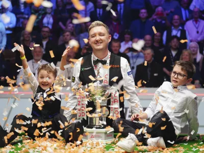 Kyren Wilson, center, celebrates with his children Finley, right, and Bailey, left, after winning the World Snooker Championship at the Crucible Theatre, Sheffield, England, Monday May 6, 2024. (Mike Egerton/PA via AP)