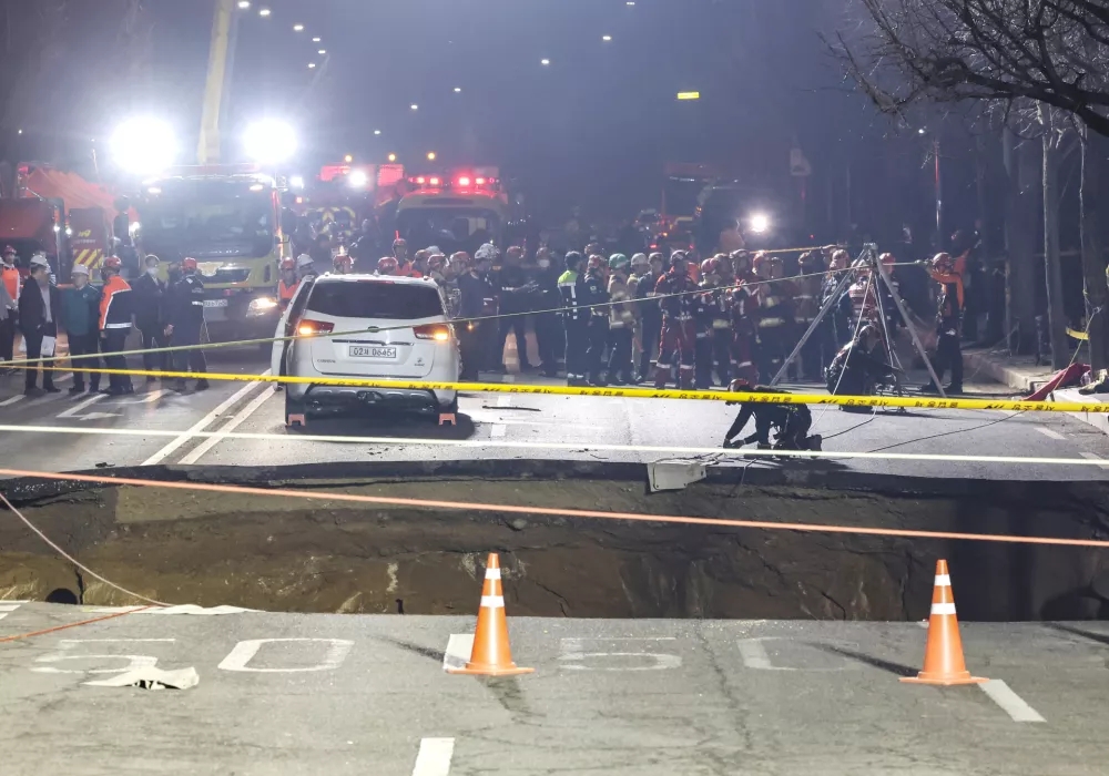 24 March 2025, South Korea, Seoul: Rescue work is underway at a 20-meter-wide sinkhole at an intersection in Seoul, Gangdong district of South Korea, after it opened up and swallowed a motorcyclist. Photo: -/Yonhap/dpa