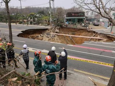 Rescue authorities inspect a sinkhole on an intersection in Seoul, South Korea, Tuesday, March 25, 2025. (Suh Dae-hyun/Yonhap via AP)