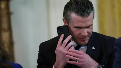 FILE PHOTO: U.S. Defense Secretary Pete Hegseth uses a phone as he attends a joint press conference of U.S. President Donald Trump and Israeli Prime Minister Benjamin Netanyahu in the East Room at the White House in Washington, U.S., February 4, 2025. REUTERS/Leah Millis/File Photo