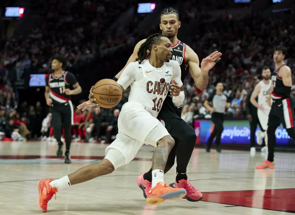 Cleveland Cavaliers guard Darius Garland (10) dribbles past Portland Trail Blazers forward Toumani Camara during the second half of an NBA basketball game in Portland, Ore., Tuesday, March 25, 2025. (AP Photo/Craig Mitchelldyer)