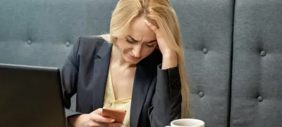 Dissatisfied surprised caucasian young woman look at smartphone screen in the home office. / Foto: Okskukuruza