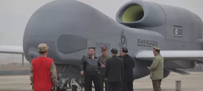 In this photo provided Thursday, March 27, 2025, by the North Korean government, its leader Kim Jong Un, center left in a black jacket, stands by what appeared to be a large reconnaissance drone at an undisclosed location in North Korea, earlier this week. Independent journalists were not given access to cover the event depicted in this image distributed by the North Korean government. The content of this image is as provided and cannot be independently verified. Korean language watermark on image as provided by source reads: "KCNA" which is the abbreviation for Korean Central News Agency. (Korean Central News Agency/Korea News Service via AP)