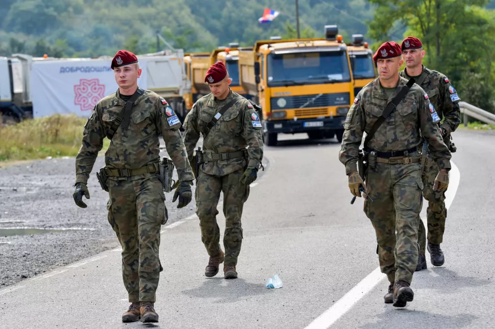 FILE PHOTO: Polish soldiers, part of the peacekeeping mission in Kosovo, KFOR, pass through barricades near the border crossing between Kosovo and Serbia in Jarinje, Kosovo, September 28, 2021. REUTERS/Laura Hasani/File Photo
