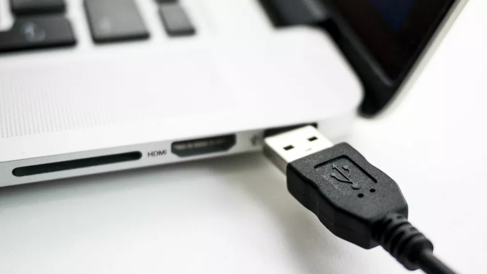 A photo illustration shows a USB device being plugged into a laptop computer in Berlin July 31, 2014. USB devices such as mice, keyboards and thumb-drives can be used to hack into personal computers in a potential new class of attacks that evade all known security protections, German crypto specialist and chief scientist with Berlin's SR Labs Karsten Nohl revealed on Thursday.  REUTERS/Thomas Peter (GERMANY - Tags: CRIME SCIENCE TECHNOLOGY)