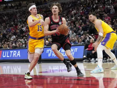 Mar 27, 2025; Chicago, Illinois, USA; Los Angeles Lakers guard Austin Reaves (15) defends Chicago Bulls forward Matas Buzelis (14) during the first quarter at United Center. Mandatory Credit: David Banks-Imagn Images