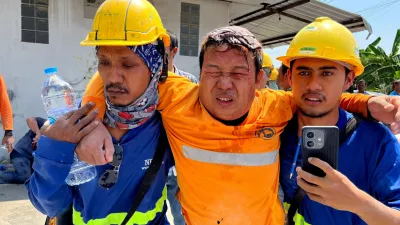Workers assist an injured man after a strong earthquake struck central Myanmar on Friday, earthquake monitoring services said, which affected Bangkok as well with people pouring out of buildings following the tremors in the Thai capital, in Bangkok, Thailand, March 28, 2025. REUTERS/Ann Wang