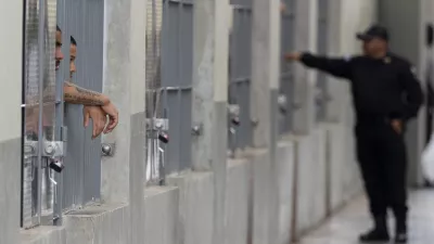 Prisoners look out their cell as Homeland Security Secretary Kristi Noem tours the Terrorist Confinement Center in Tecoluca, El Salvador, Wednesday, March 26, 2025. (AP Photo/Alex Brandon)