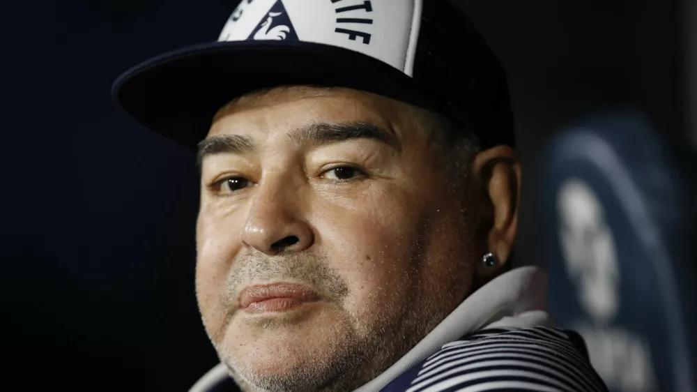 FILE - In this March 7, 2020 file photo, Diego Maradona, coach of Gimnasia y Esgrima, sits on the bench prior to Argentina's soccer league match against Boca Juniors at La Bombonera stadium in Buenos Aires, Argentina. Maradona turns 60 on Friday, Oct. 30, 2020. (AP Photo/Natacha Pisarenko, File)