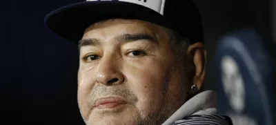 FILE - In this March 7, 2020 file photo, Diego Maradona, coach of Gimnasia y Esgrima, sits on the bench prior to Argentina's soccer league match against Boca Juniors at La Bombonera stadium in Buenos Aires, Argentina. Maradona turns 60 on Friday, Oct. 30, 2020. (AP Photo/Natacha Pisarenko, File)