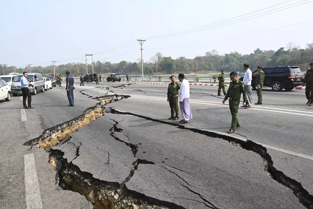 In this image provided by The Myanmar Military True News Information Team, Myanmar's military leader Senior Gen. Min Aung Hlaing, center, inspects damaged road caused by an earthquake Friday, March 28, 2025, in Naypyitaw, Myanmar. (The Myanmar Military True News Information Team via AP)