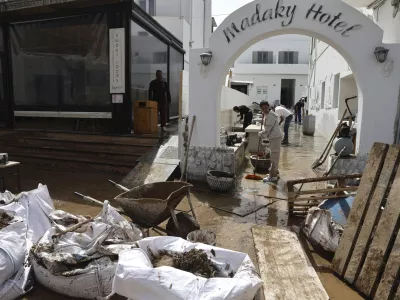 People try to clear the mud from a hotel after a powerful storm which has triggered widespread flooding at the port of Naousa, on the Aegean Sea island of Paros, Greece, Tuesday, April 1, 2025. (John Liakos/InTime News via AP)