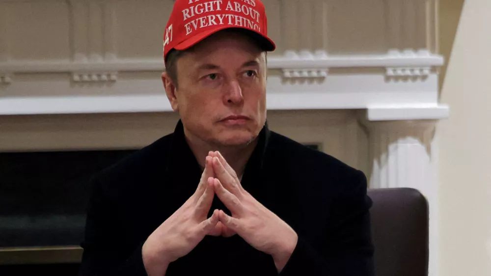 FILE PHOTO: Tesla CEO Elon Musk wears a 'Trump Was Right About Everything!' hat while attending a cabinet meeting at the White House, in Washington, D.C., U.S., March 24, 2025. REUTERS/Carlos Barria/File Photo