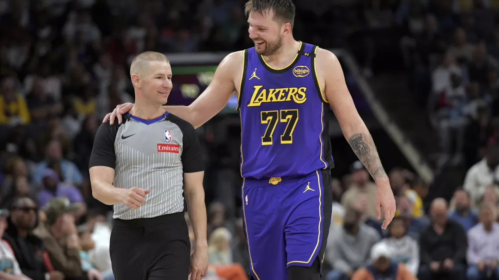 Los Angeles Lakers guard Luka Doncic (77) talks with referee Tyler Ford in the second half of an NBA basketball game against Memphis Grizzlies Saturday, March 29, 2025, in Memphis, Tenn. (AP Photo/Brandon Dill)
