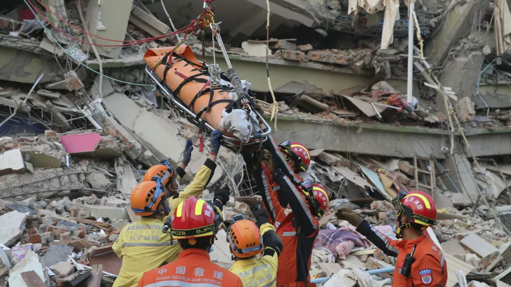 In this photo released by Xinhua News Agency, members of a China search and rescue team transfer a pregnant survivor from a collapsed building in the aftermath of an earthquake in Mandalay, Myanmar, Monday, March 31, 2025. (Myo Kyaw Soe/Xinhua via AP)