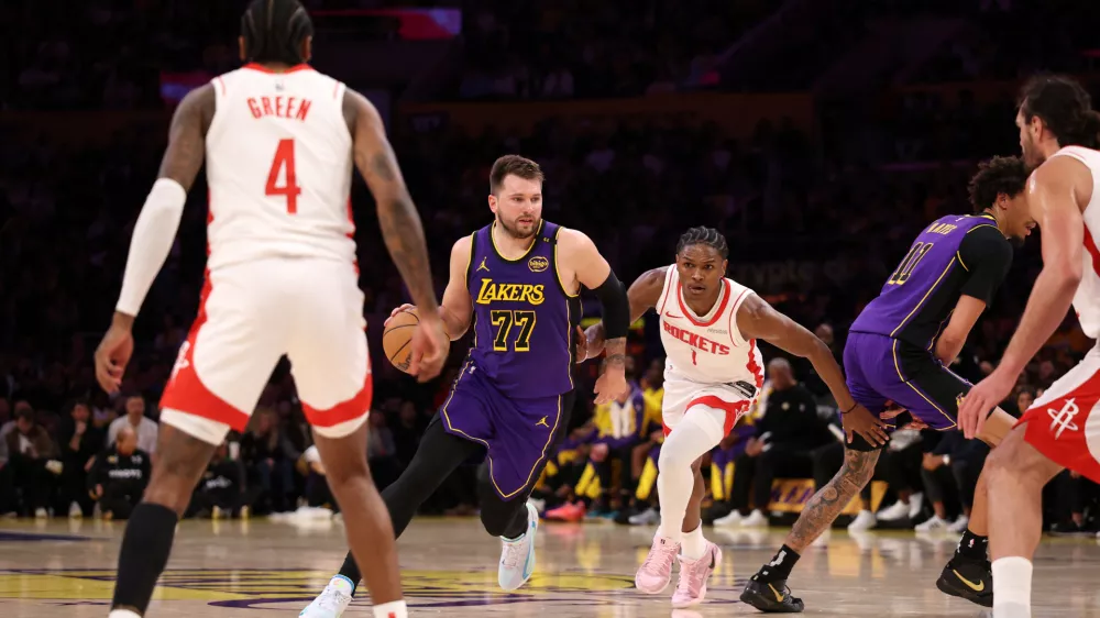 Mar 31, 2025; Los Angeles, California, USA; Los Angeles Lakers guard Luka Doncic (77) dribbles the ball against Houston Rockets forward Amen Thompson (1) during the first half at Crypto.com Arena. Mandatory Credit: Kiyoshi Mio-Imagn Images