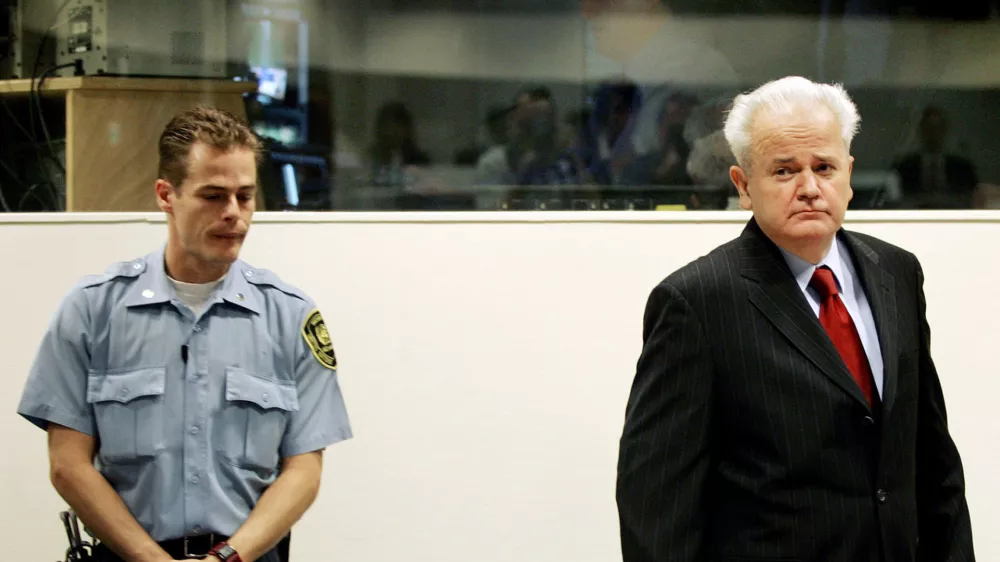 Former Yugoslav President Slobodan Milosevic (R) enters the courtroom for the start of his defence case at the Yugoslav war crimes tribunal in the Hague, July 5, 2004. Milosevic appeared at tribunal on Monday but the start of his defence was in doubt with a judge raising concerns about the defendant's health.  REUTERS/Bas Czerwinski/Pool