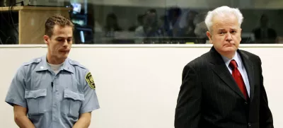 Former Yugoslav President Slobodan Milosevic (R) enters the courtroom for the start of his defence case at the Yugoslav war crimes tribunal in the Hague, July 5, 2004. Milosevic appeared at tribunal on Monday but the start of his defence was in doubt with a judge raising concerns about the defendant's health.  REUTERS/Bas Czerwinski/Pool
