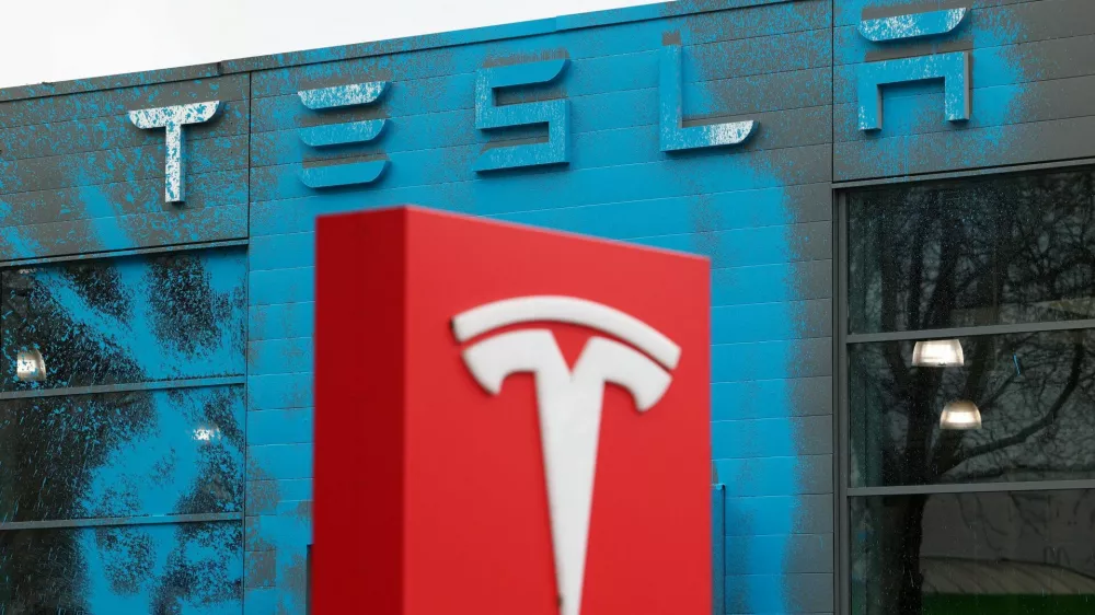 Blue paint covers the facade of a Tesla dealership after it was sprayed by supporters of New Generation (Neue Generation) during a protest against Elon Musk and against what organisers say is the destruction of democracy and the climate by the rich, in Berlin, Germany, March 31, 2025. REUTERS/Christian Mang   TPX IMAGES OF THE DAY