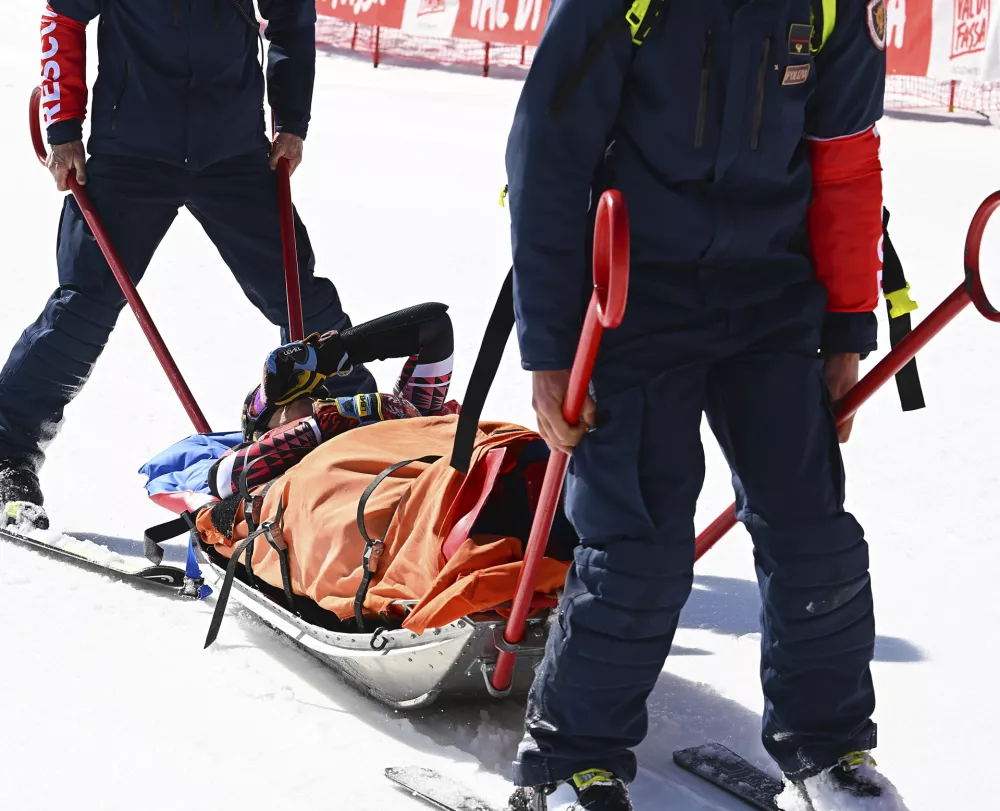 Italy's Federica Brignone is carried away on a toboga after she broke multiple bones in her left leg during a giant slalom crash at the Italian championships in the Lusia ski area, in Val di Fassa, Italy, Thursday, April 3, 2025. (AP Photo/Elvis Piazzi)