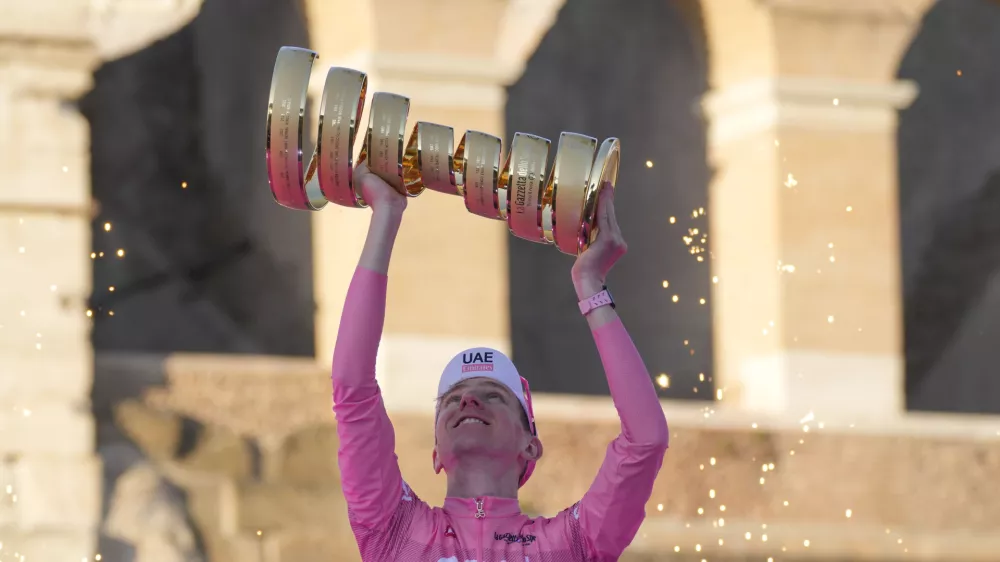 Tour of Italy winner Slovenia's Tadej Pogacar holds up the trophy during the podium ceremony at the end of the 21st and last stage of the Giro D'Italia, cycling race, in Rome, Sunday, May 26, 2024. (AP Photo/Andrew Medichini)
