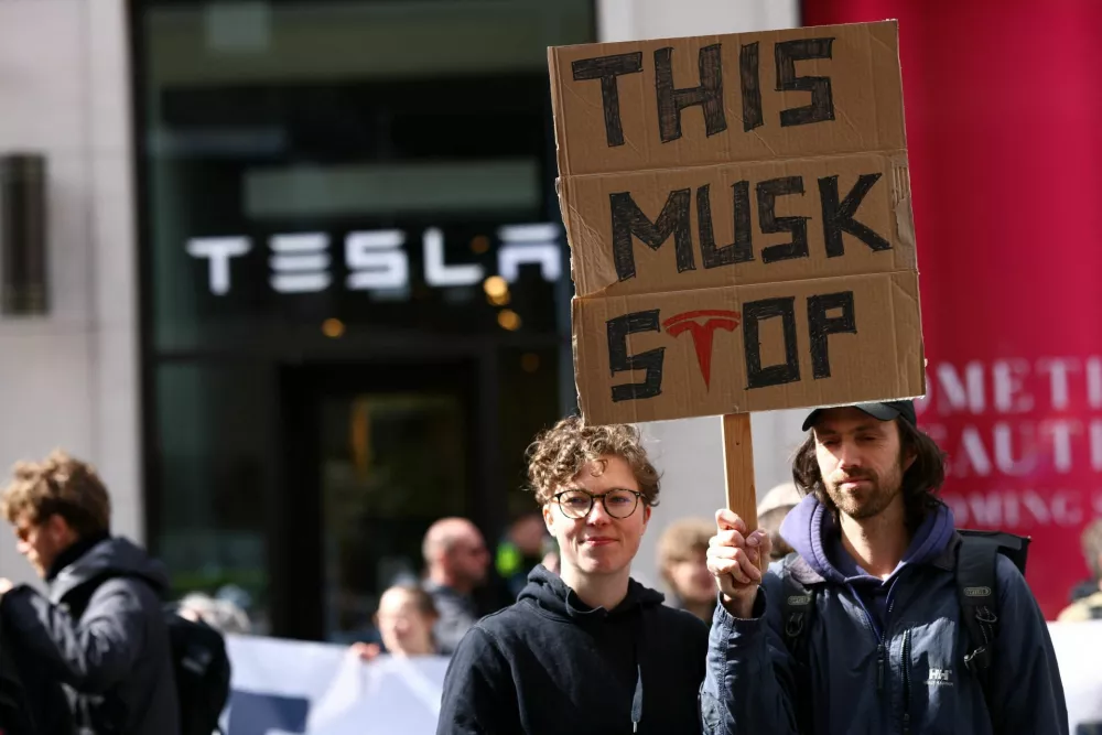 People take part in a protest outside a Tesla showroom at Mall of Berlin under the slogan "#TeslaTakedown" against Tesla and its CEO Elon Musk and against what organisers say is the destruction of democracy and the climate by the rich, in Berlin, Germany, April 5, 2025. REUTERS/Christian Mang