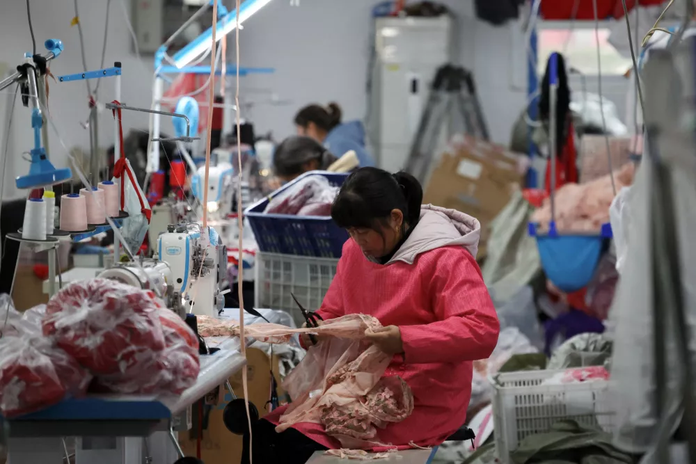FILE PHOTO: Employees work on the production line at the Midnight Charm Garment lingerie factory in Guanyun county of Lianyungang, Jiangsu province, China November 25, 2024. REUTERS/Florence Lo/File Photo